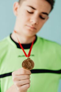 Portrait of a young athlete proudly displaying a gold medal, symbolizing victory and achievement.